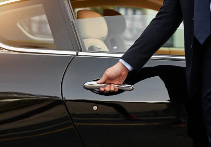 Businessman, hands and chauffeur by car door for travel accommodation, designated driver or commute. Hand of male person on vehicle handle in professional transport service, business class or pick up.